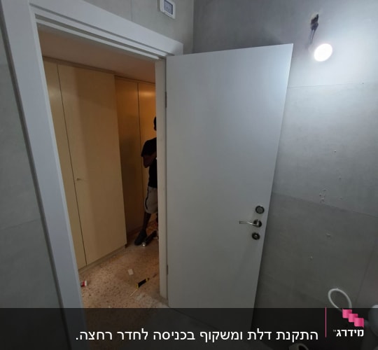 דלת פתוחה עם אדם ברקע בחדר